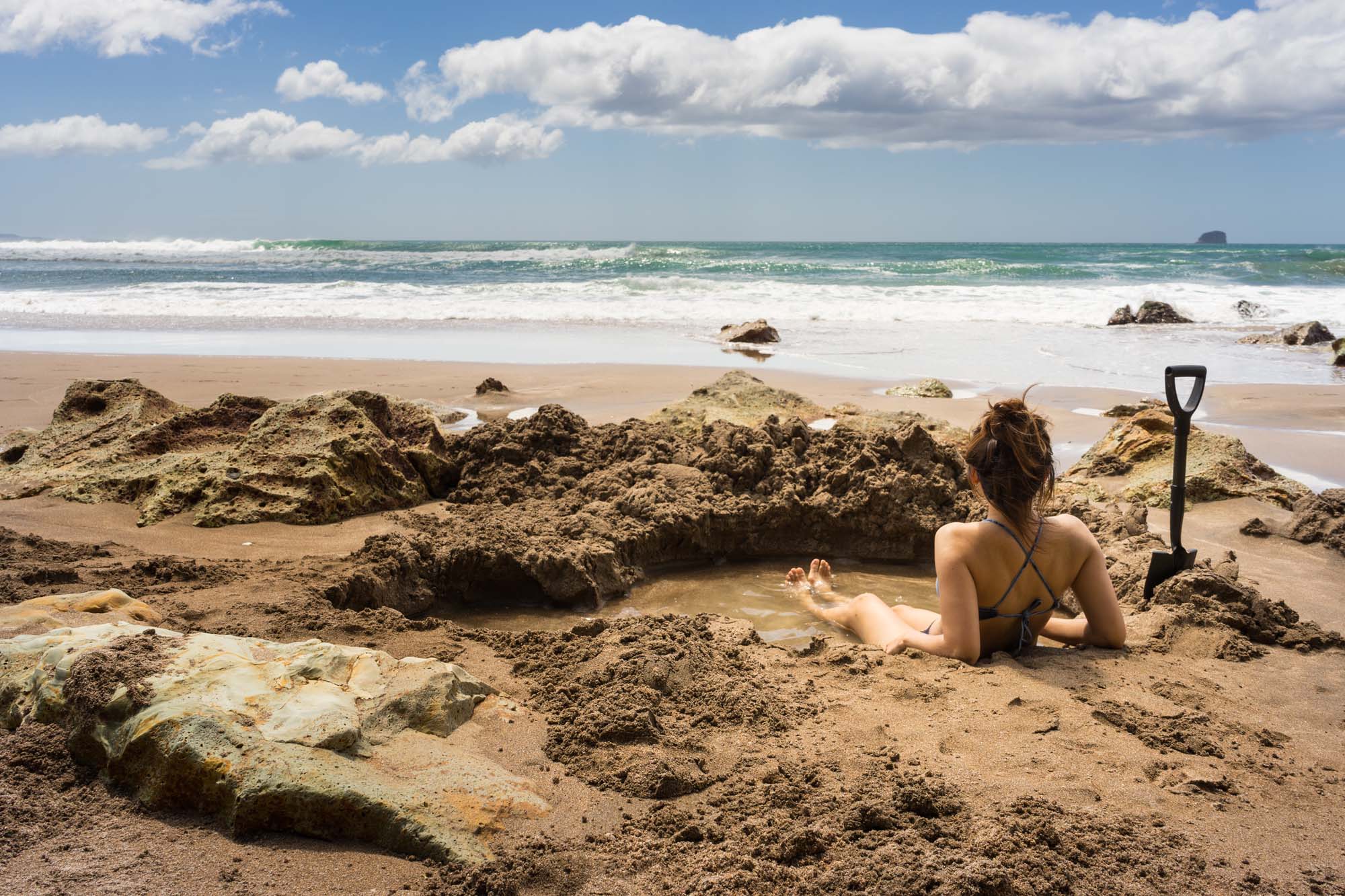 new-zealand-coromandel-mercury-bay-hot-water-beach-woman-in-thermal-pool-shutterstock_554194648