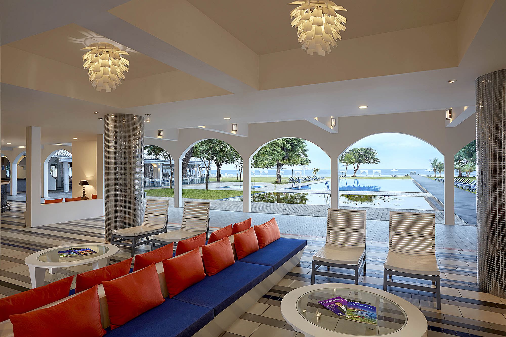 Hotellets lobby indrettet i moderne stil med pool- og havudsigt