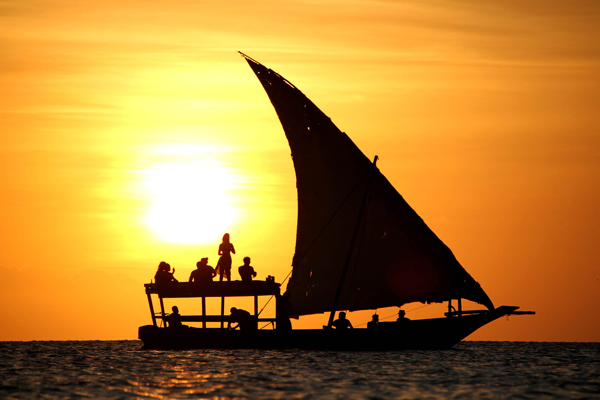 Dhow-båd i flot solnedgang ved Zanzibars kyst.