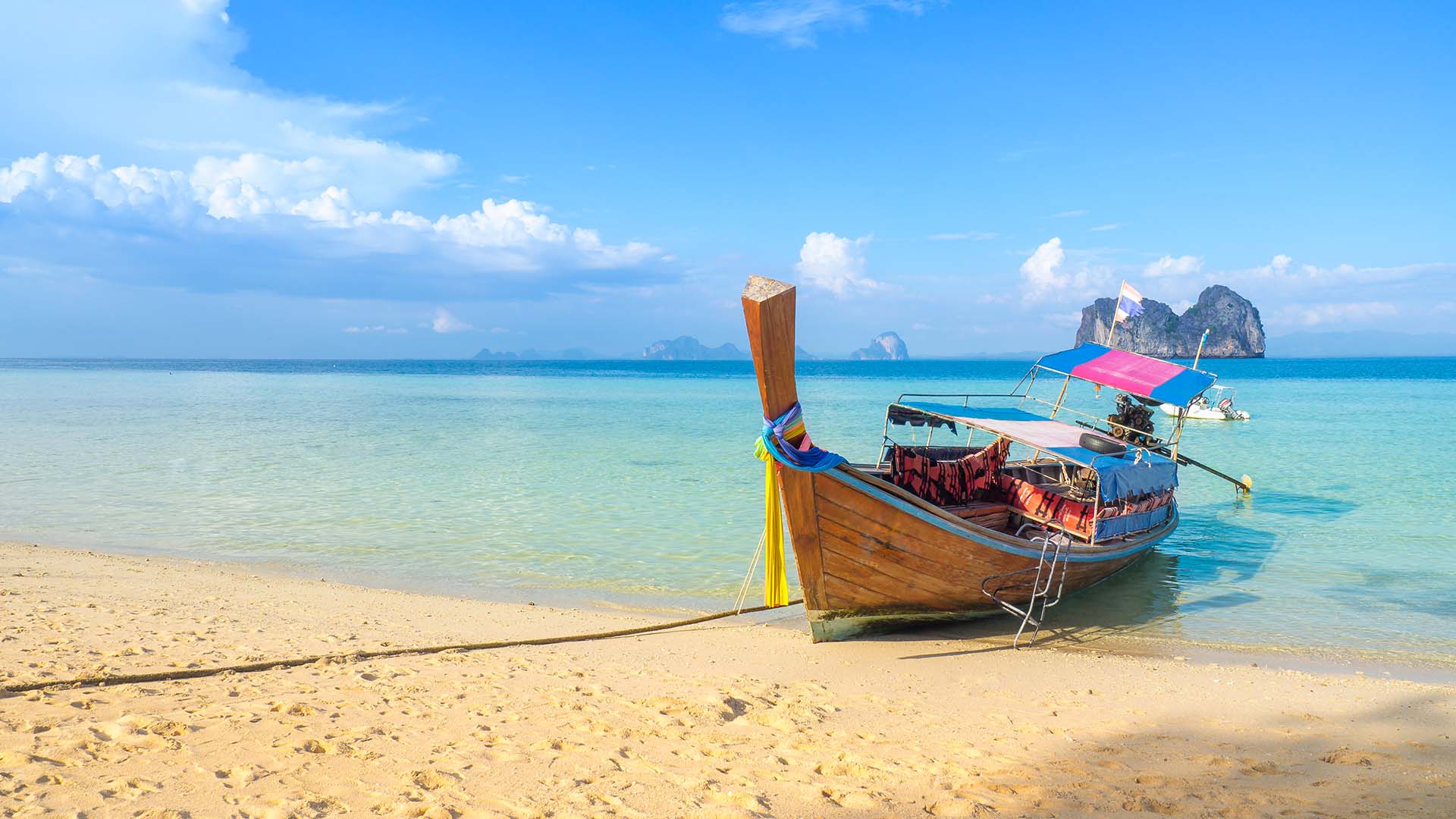 Stranden på Koh Ngai med det klare vand og en typisk thailandsk longtail-båd.