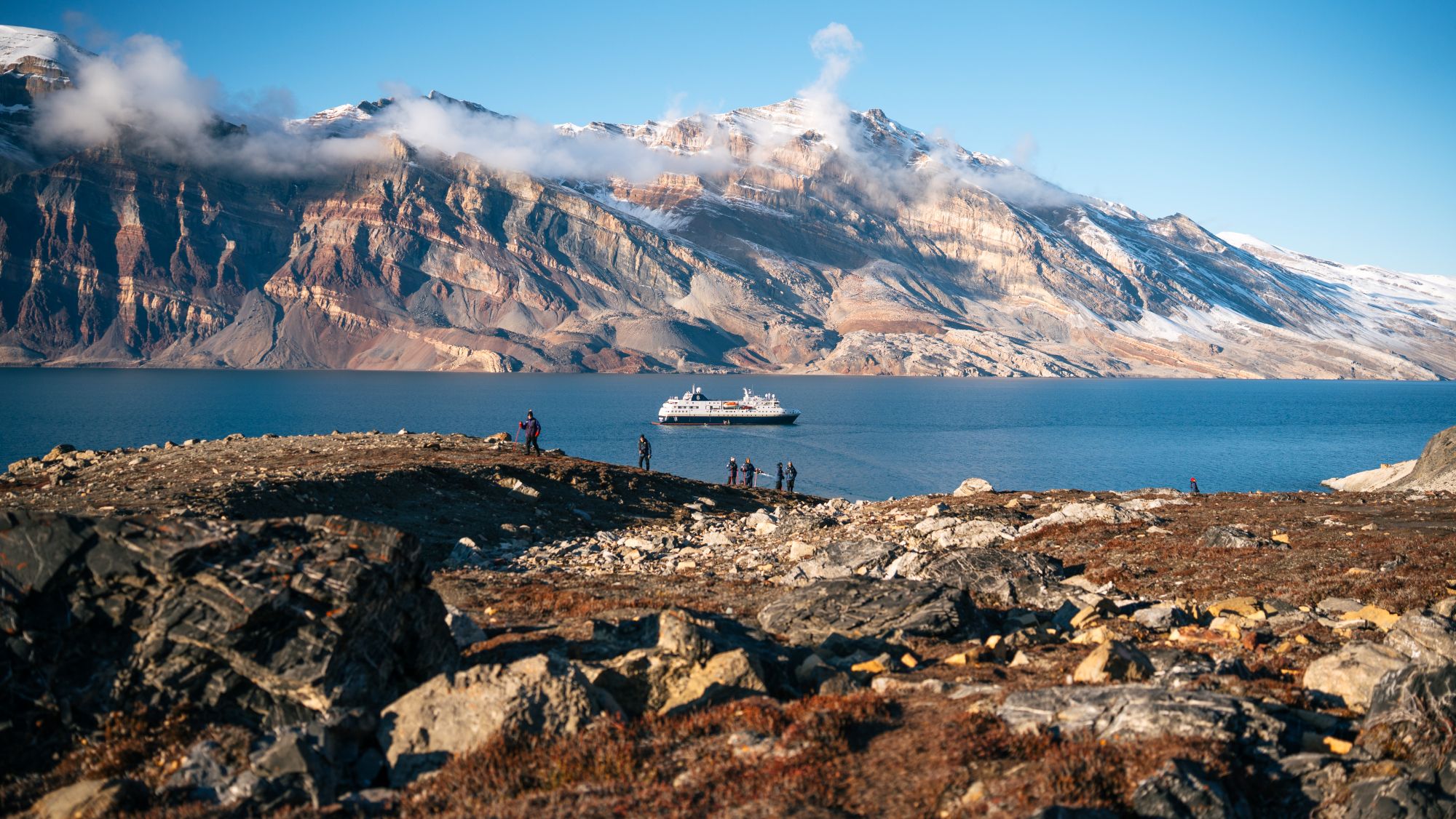 MS Fridtjof Nansen i det storslåede arktiske landskab, omgivet af mægtige fjelde og fjorde | Foto: Kay Fochtmann/HX