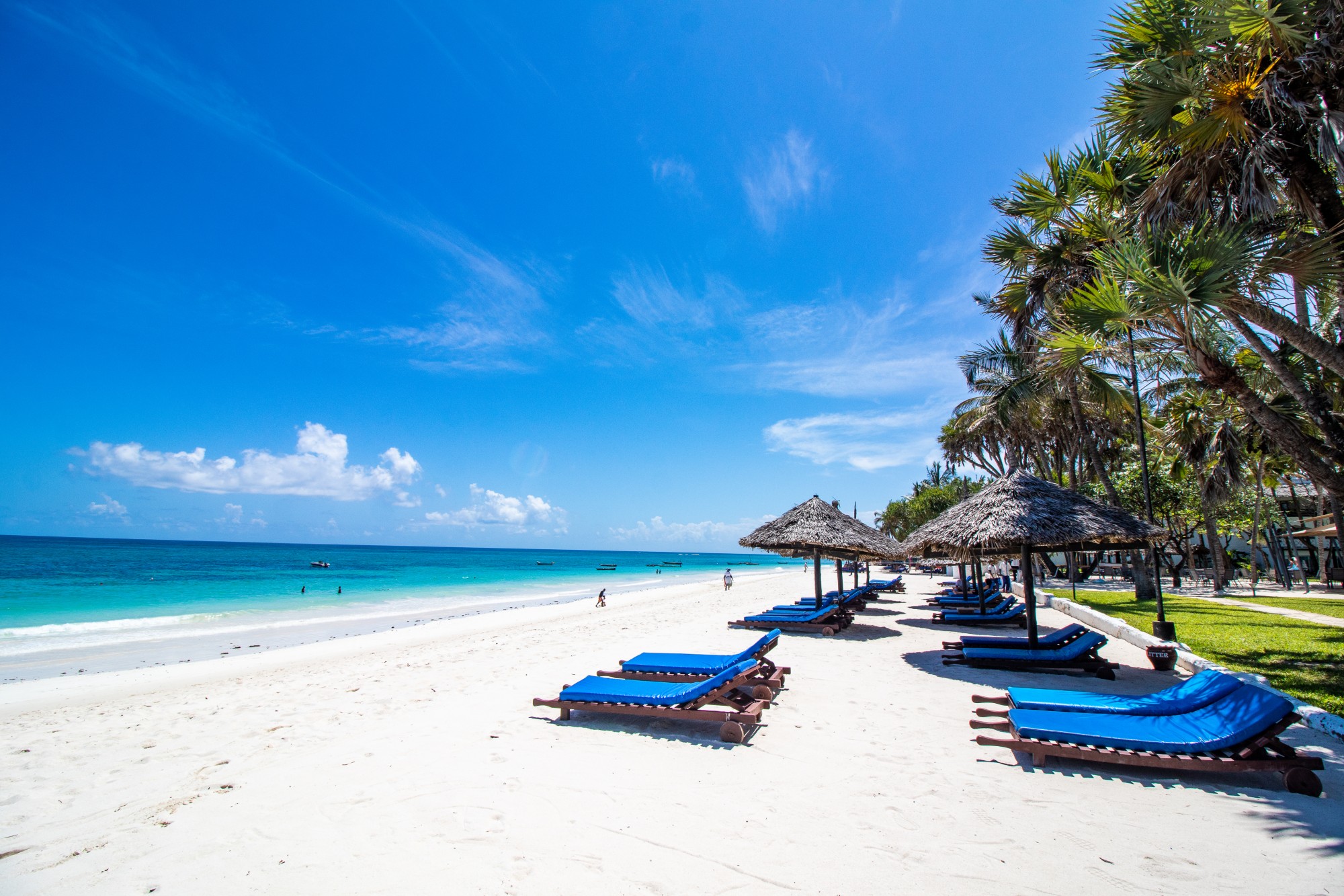 På stranden findes solsenge og parasoller, der inviterer til at nyde livet fuldt ud